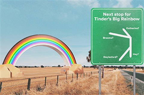 A big rainbow sculpture sits in a regional field