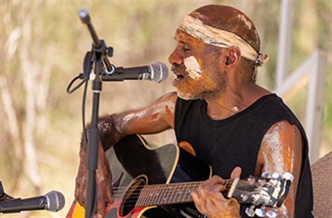 Artist Amos Roach singing and play the guitar