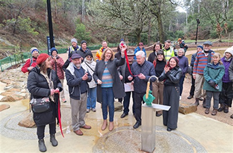 Group of people cutting a red ribbon