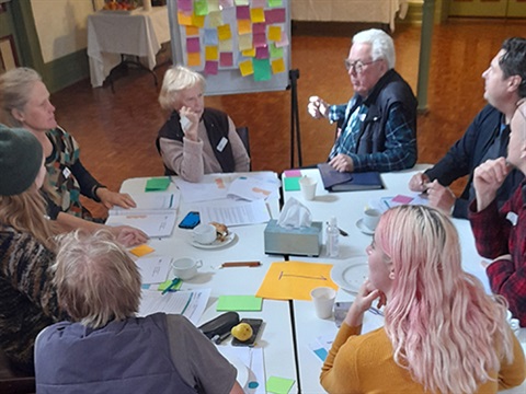 Community members sitting around a table during deliberative engagement 