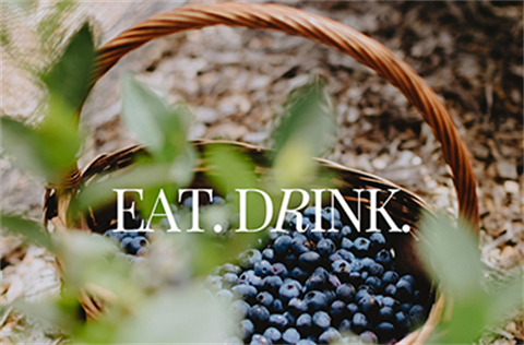 A basket with freshly picked blackberries and the words 'eat and drink'