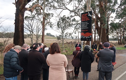 A group of people standing next to the Frontier Wars Memorial