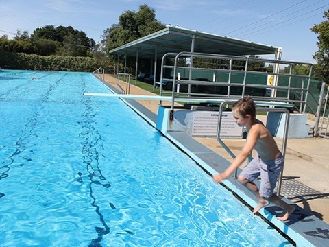 Child jumping into swimming pool
