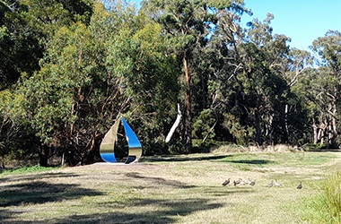The Drop artwork sitting in the landscape at Glenlyon dam with trees in the background