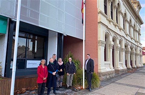 People standing under the aboriginal flag which has been raised